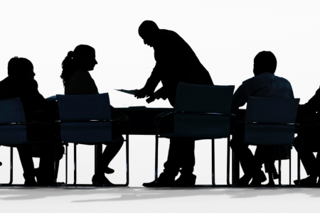 silhouette of people in a meeting at desks