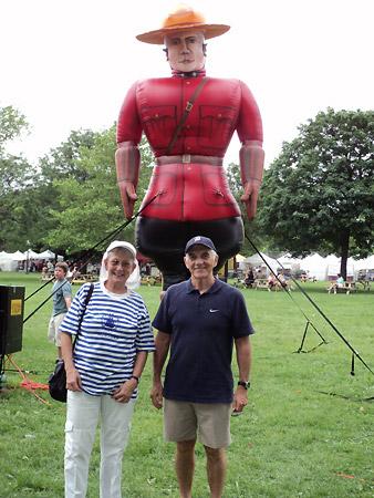 Patsy Paxton and Alan Wright stand in front of a 15 foot high inflatable RCMP officer at Willistead Manor.