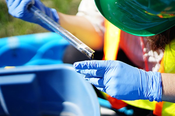 student pouring sludge from test tube