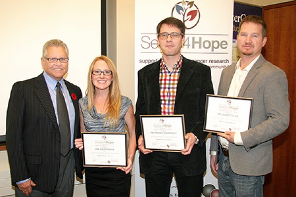 Seeds4Hope administrator Michael Dufresne congratulates research grant recipients Lisa Porter, Phillip Karpowicz and James Gauld.