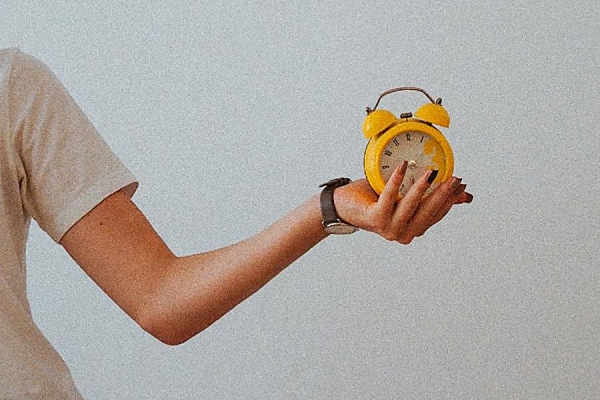 arm extended holding alarm clock