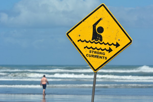 beach with sign warning &quot;strong currents&quot;