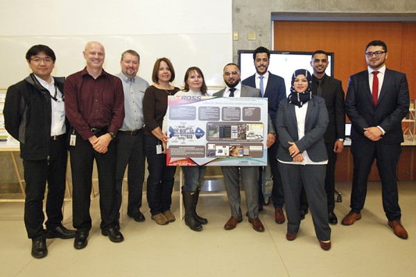 Members of a capstone team pose with TRQSS employees at the industrial engineering capstone presentation day, March 31.