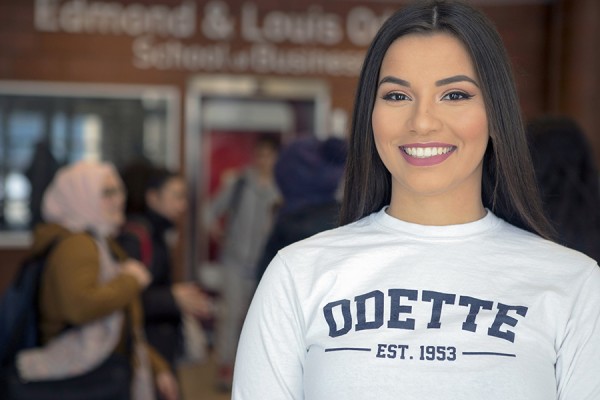 business student stands in lobby of Odette Building