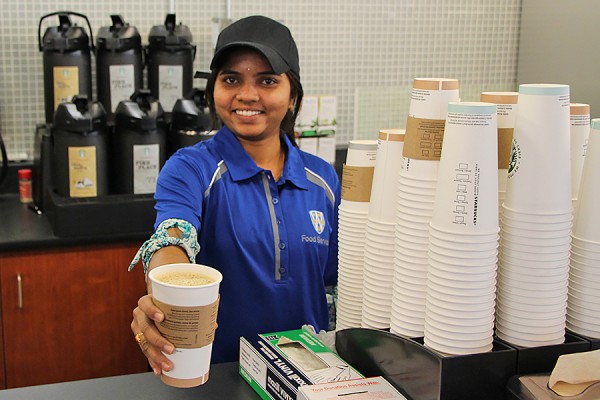 woman serving cup of Starbucks coffee