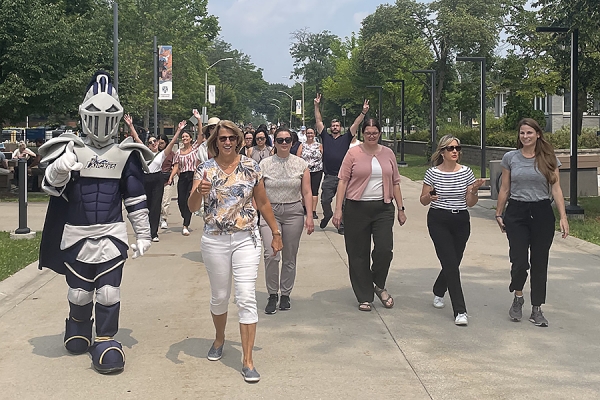 Winston, a plush knight, lead a group of walkers