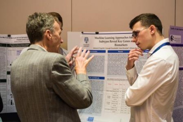 Clinicians and students discuss poster projects during the Biennial International Cancer Research Conference.
