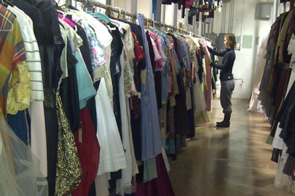 Student Anna Toaze sorts costumes in a drama storage room.