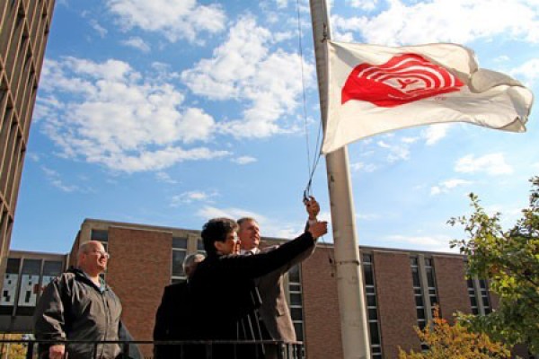 Members of the United Way campaign team raise the charity’s flag outside Chrysler Hall Tower