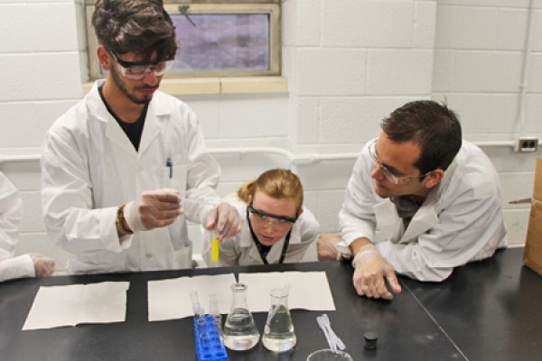 student pouring liquid into test tube