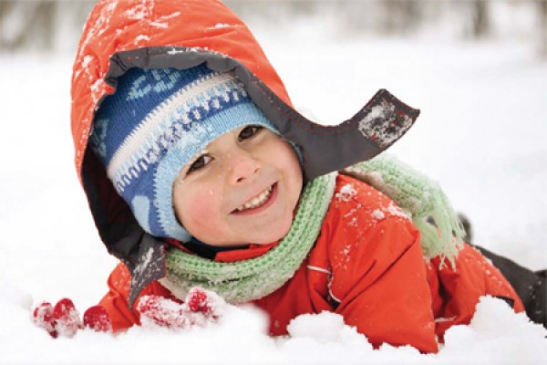 Kid wearing winter coat playing in snow