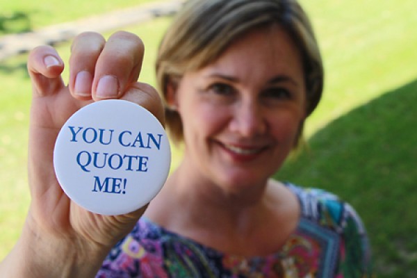 Lori Lewis holding up button that reads &quot;You can quote me!&quot;