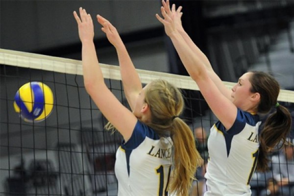 Volleyball players go up for a block