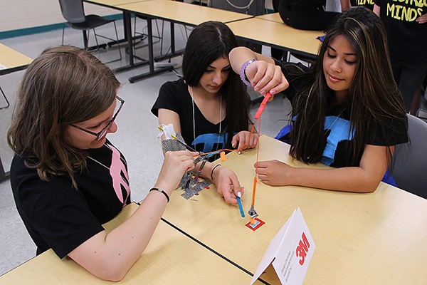students from St. John de Brebeuf elementary school bent over project