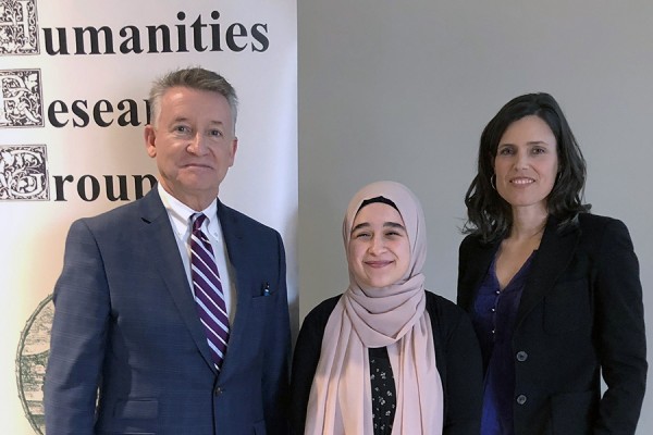 Last year’s “Why Humanities?” competition winner, Rima Asfour (centre), accepts congratulations from UWindsor provost Douglas Kneale and Humanities Research Group director Kim Nelson.