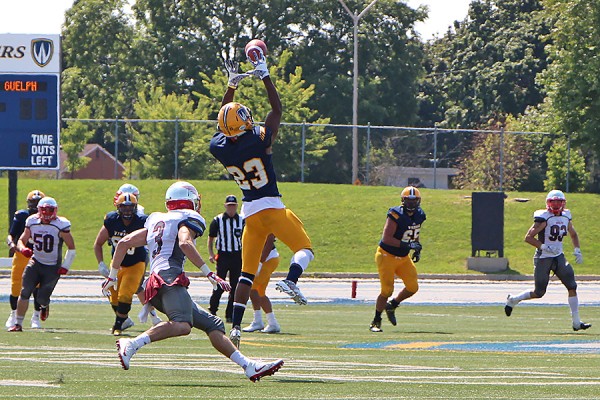 football player leaps to make catch