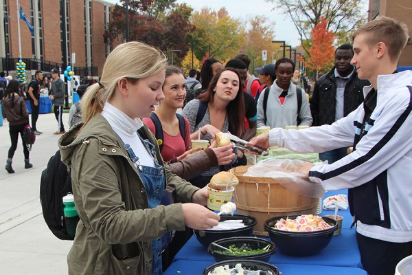 Jaime Nantais and other students customize their chili with toppings.