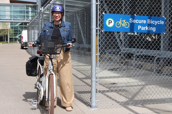 Nicole Noel on bike next to fenced shelter