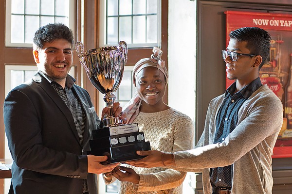Jon O’Beid accepts the Ontario Science Games trophy from conveners Bolade Ajarat Shipeolu and Jhanahan Sriranjan
