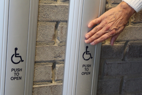 hand pressing door access button