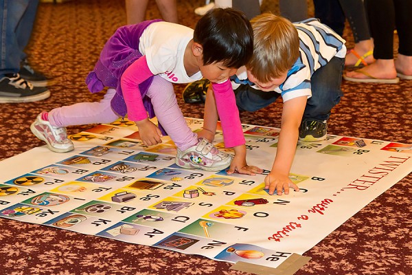 toddlers playing Twister on a periodic table of elements