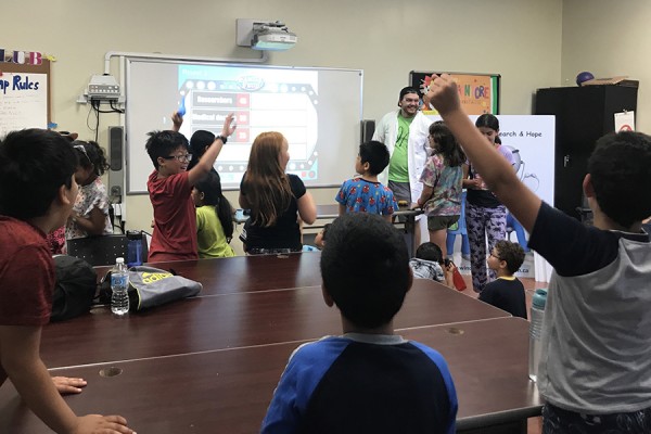 Kids play “Family Feud” at the YMCA pilot of a cancer research summer camp.