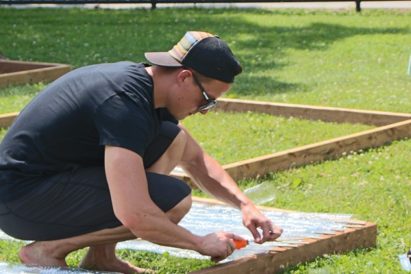 MBA student Connor Paterson worked with his team on building a green greenhouse made almost entirely of recyclable plastic water bottles, Monday, June 22.