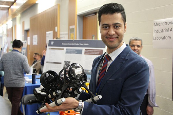 Doctoral student Faraz Talebpour shows off a remote-controlled underwater vehicle.