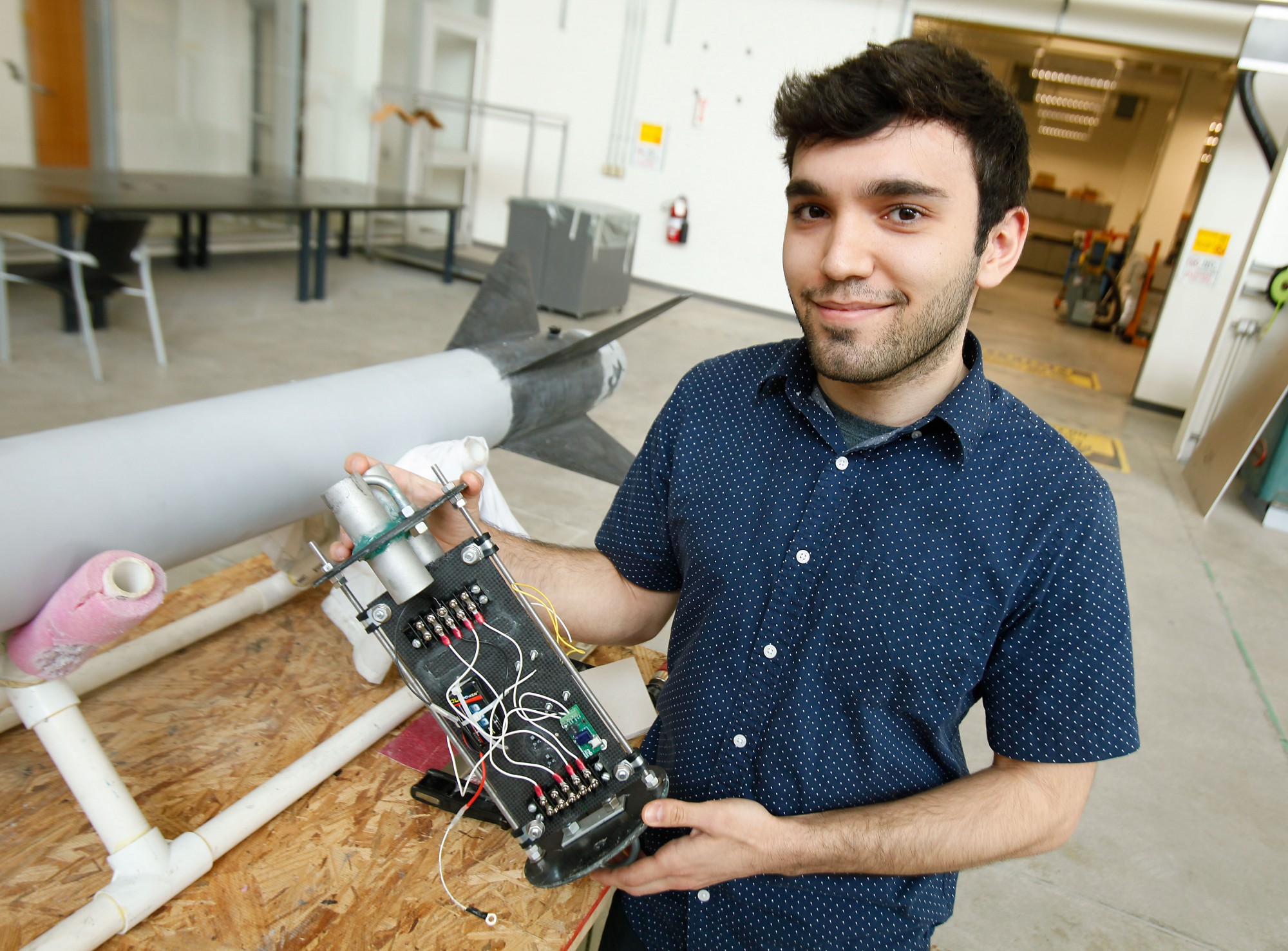 Aerospace student Atilla Saadat holds an avionics bay, which will log the altitude of a rocket