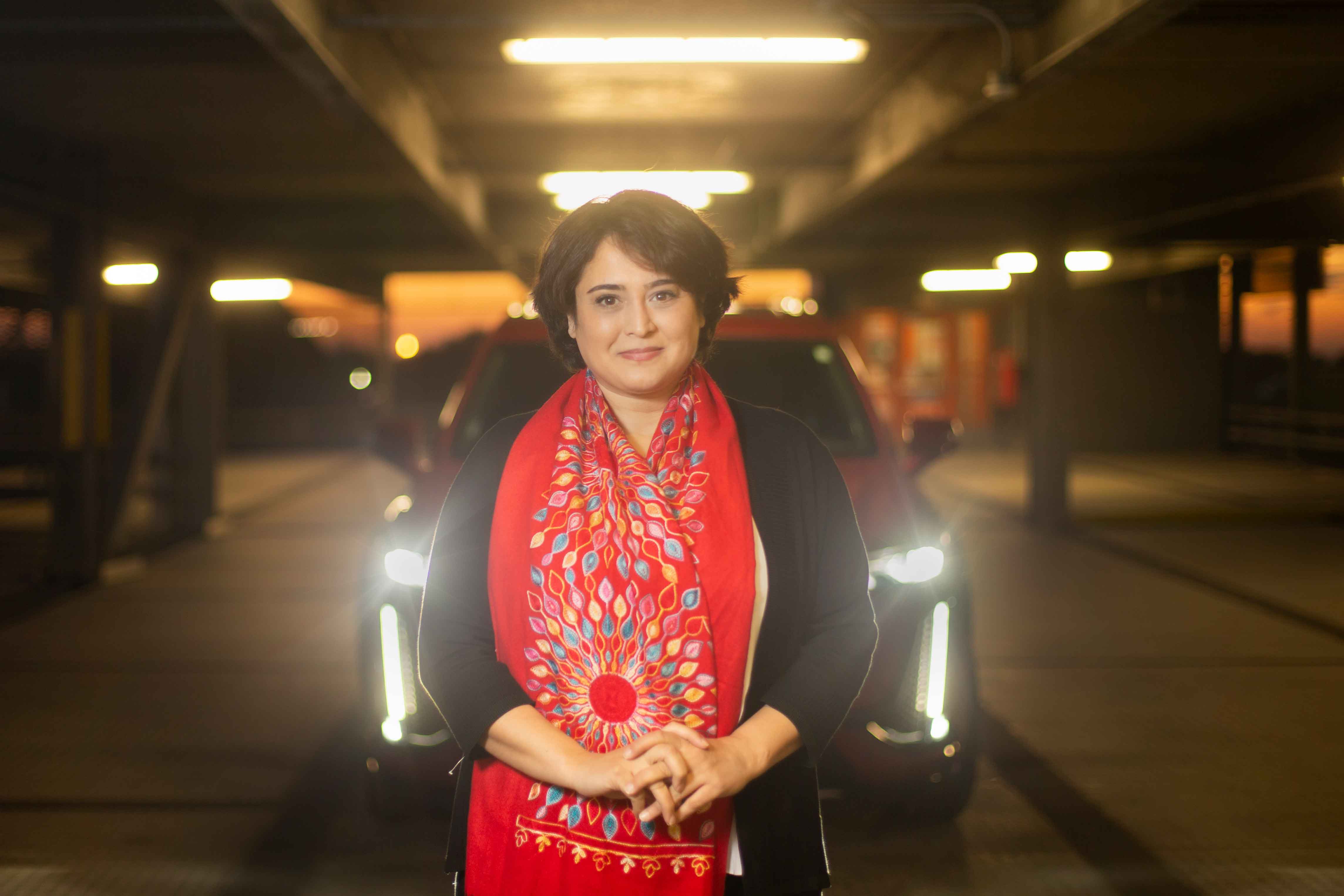 Dr. Mitra Mirhassani poses in front of a vehicle