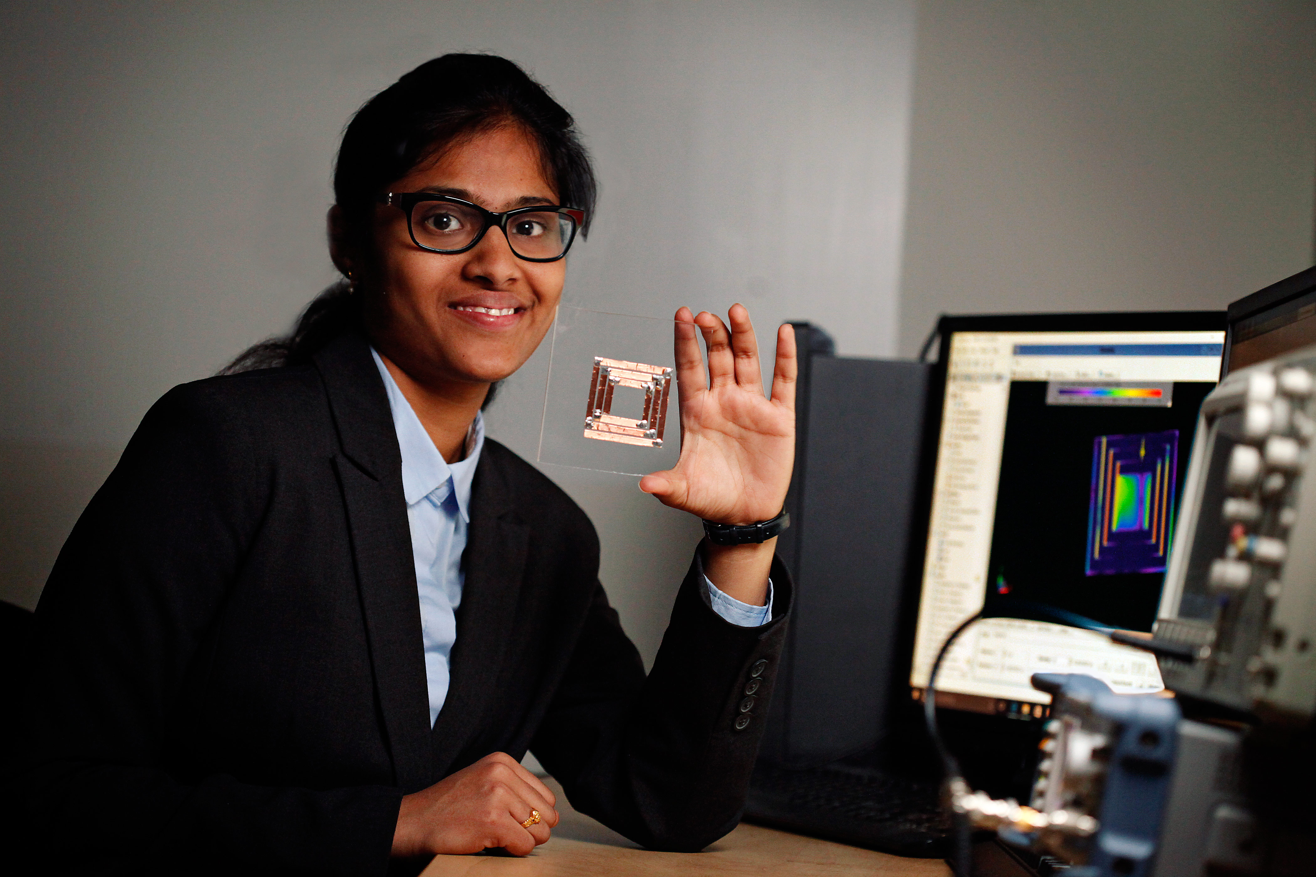 Female engineering student wearing glasses showing his work.