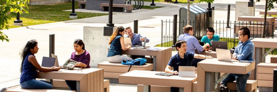 Group of diverse students conversing outdoors on campus