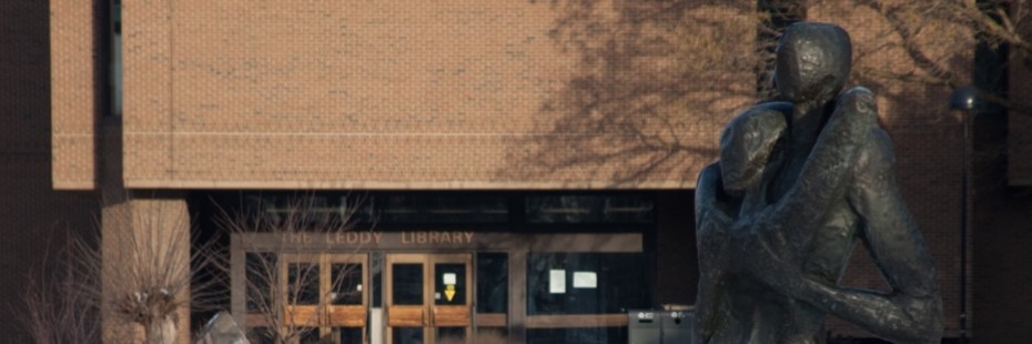 Photo of main face of Leddy Library with statue in foreground