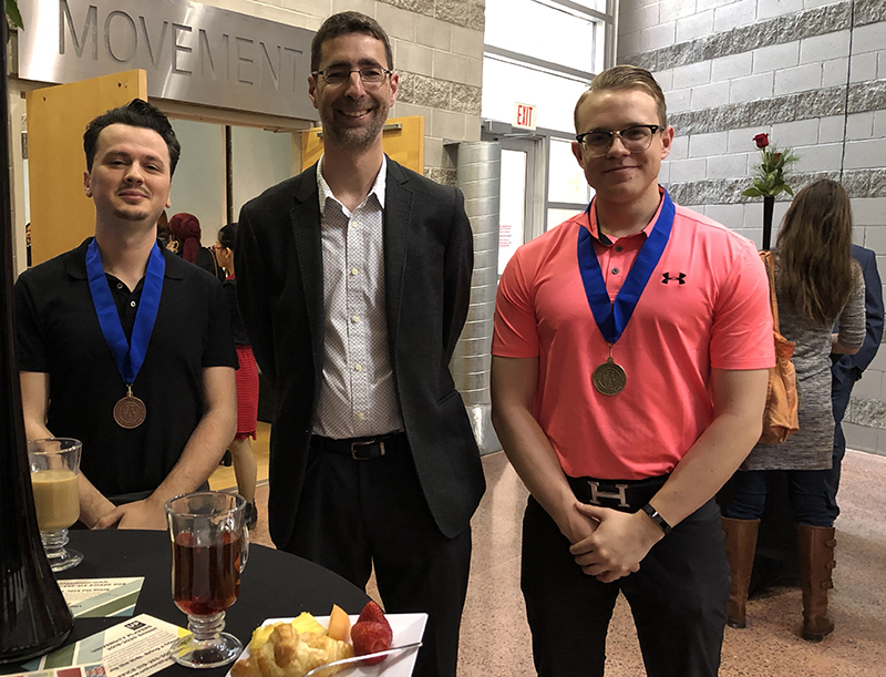 Gold Medallion recipient Mark McWhinney, double honours in Political Science and History with a minor in Greek & Roman Studies; and bronze medallion recipient Francesk Perpalaj, political science major, with Dr. John Sutcliffe, Political Science head.