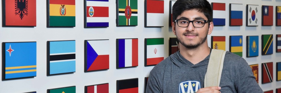Male student standing in front of flags at International Student Centre