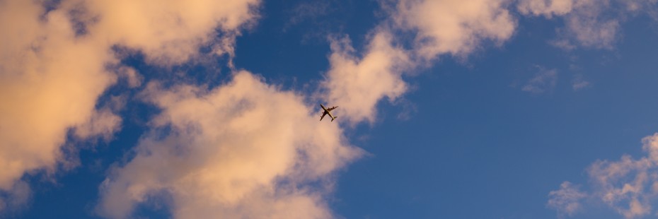 Photo of an airplane against a blue sky with white clouds