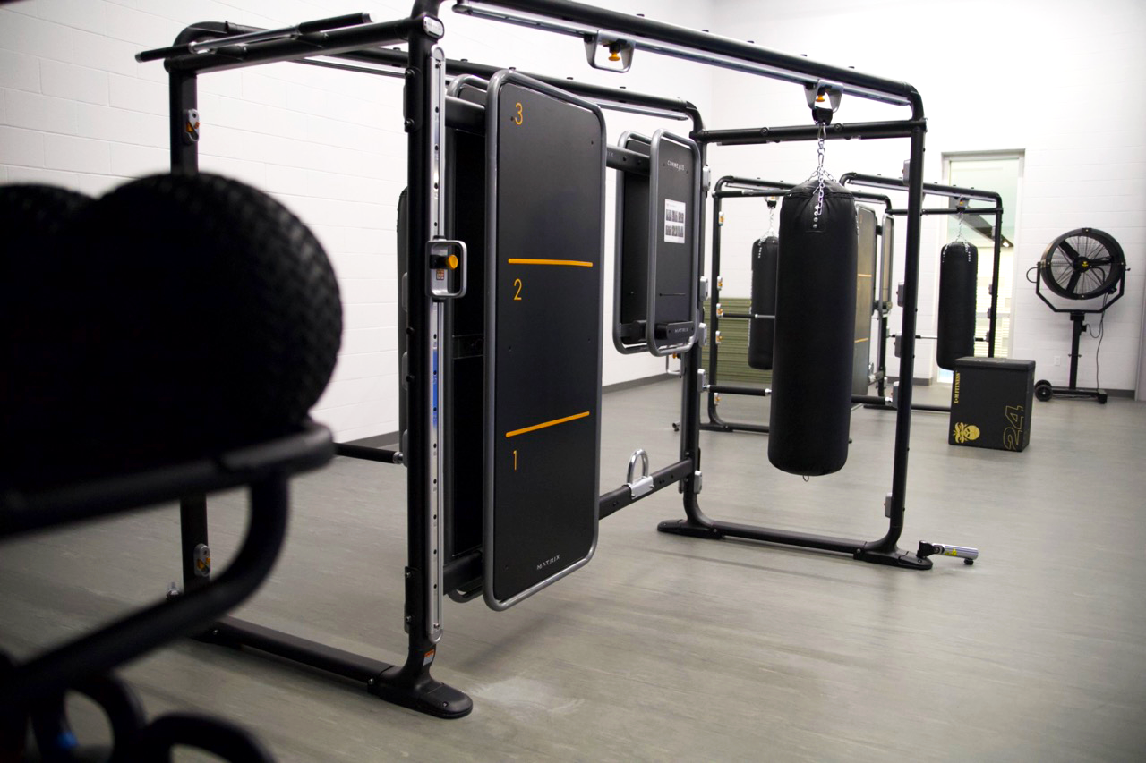 Martial arts room with boxing bags hung up.