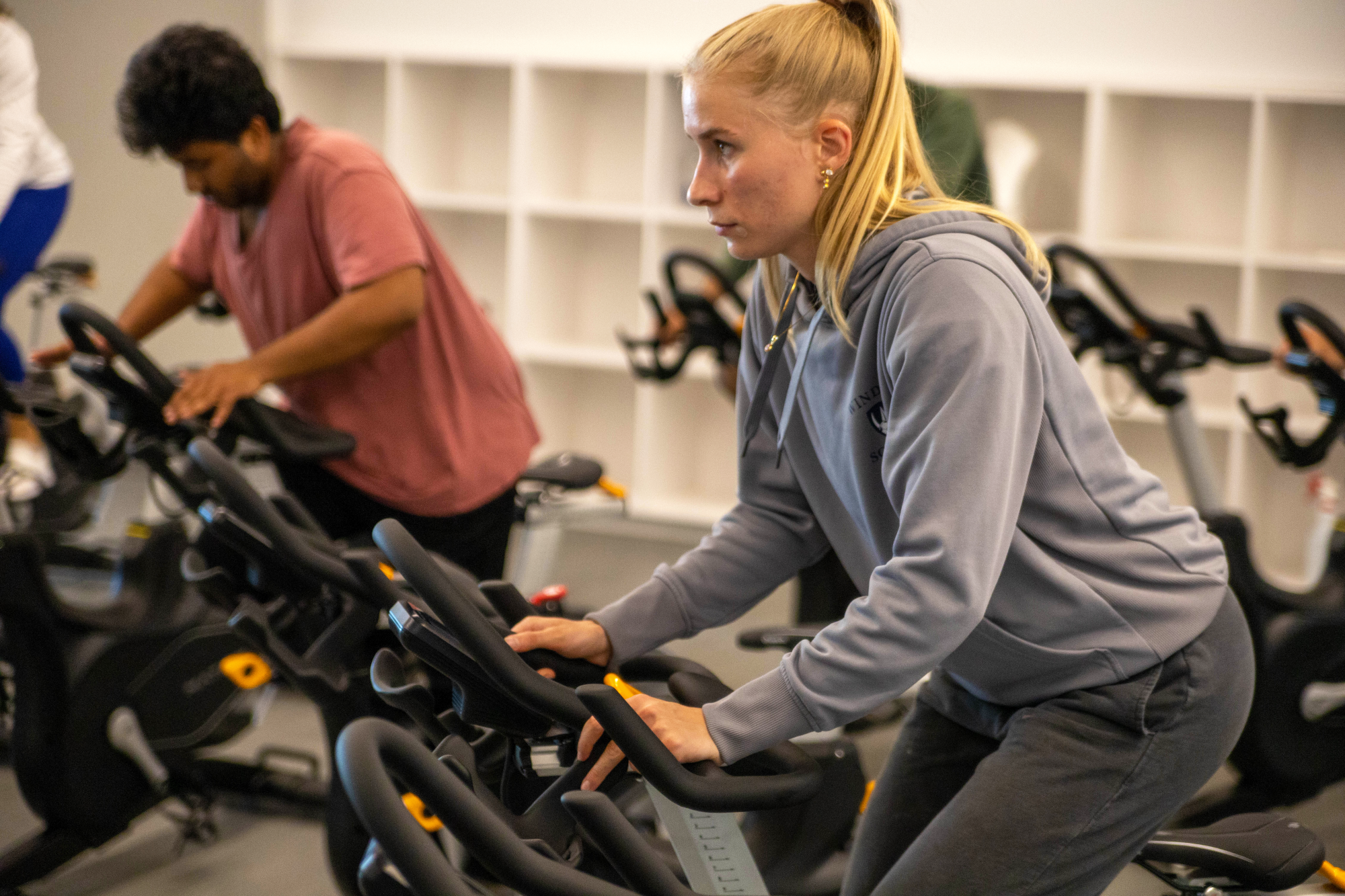 Student biking on stationary bike in a spin class.