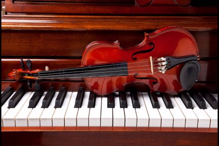 Image of a violin sitting on a piano