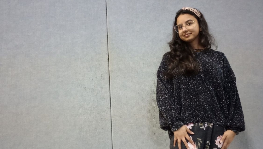 Samita Sarkar in front of a grey background wearing heart shaped glasses