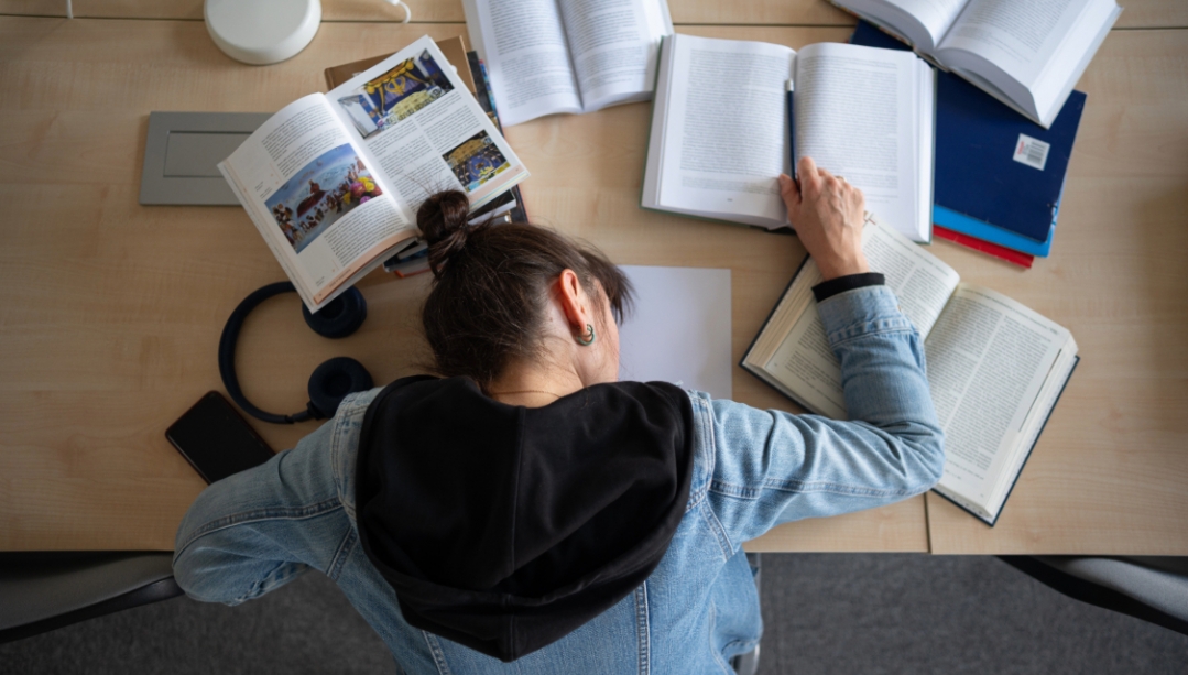 Woman sleeping on text books