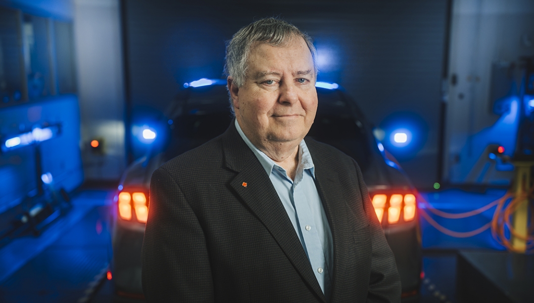 phot of Dr. Peter Frise in front of an electric vehicle