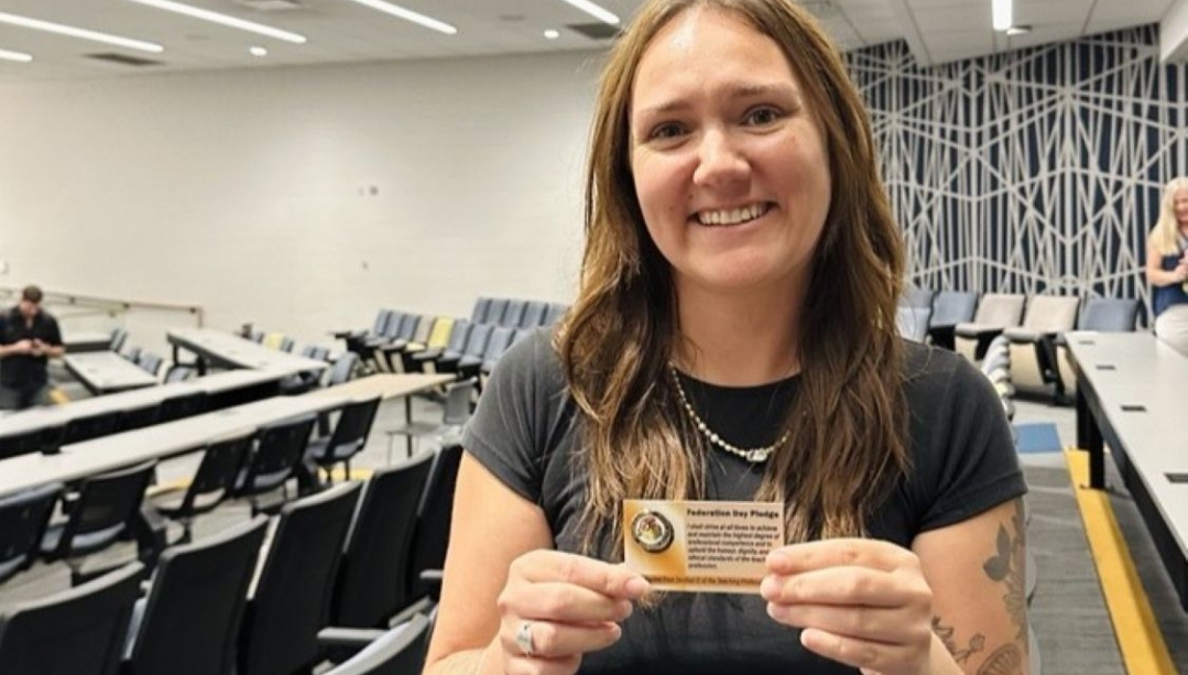 Smiling woman holding a pin on a card