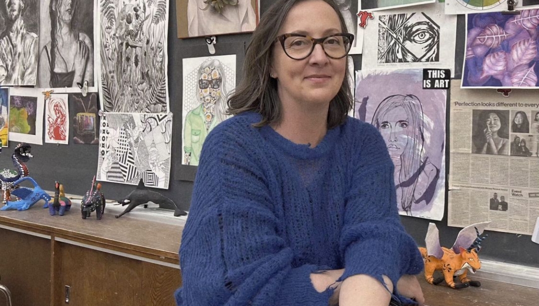 Sanja Srdanov in front of a wall of student art
