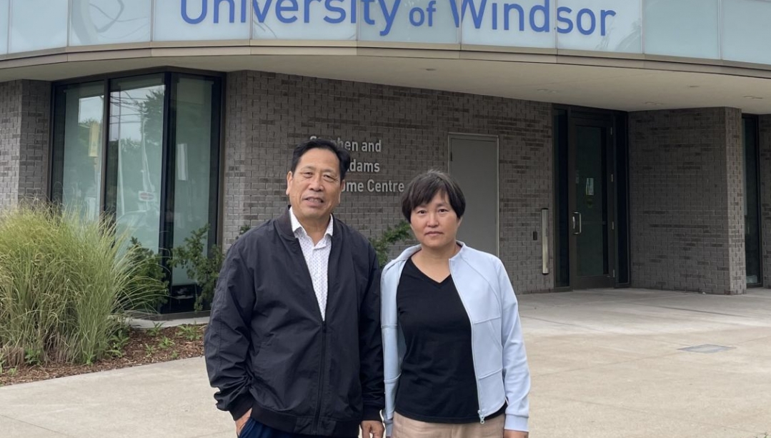 George Zhou and Guifang Cheng in front of the UWindsor Welcome Centre