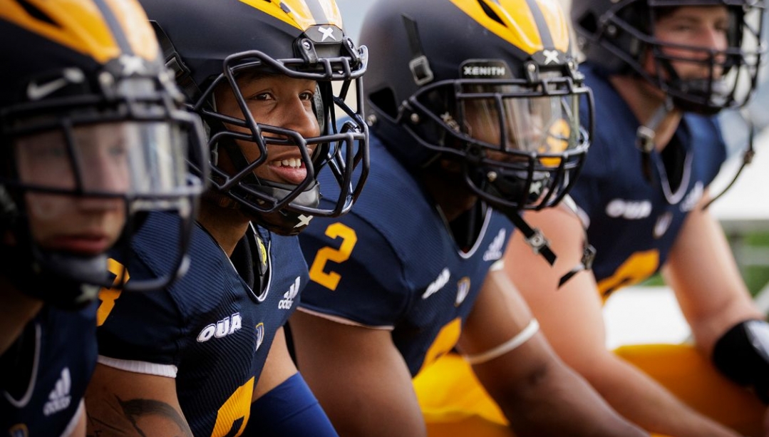 Four football players in helmets