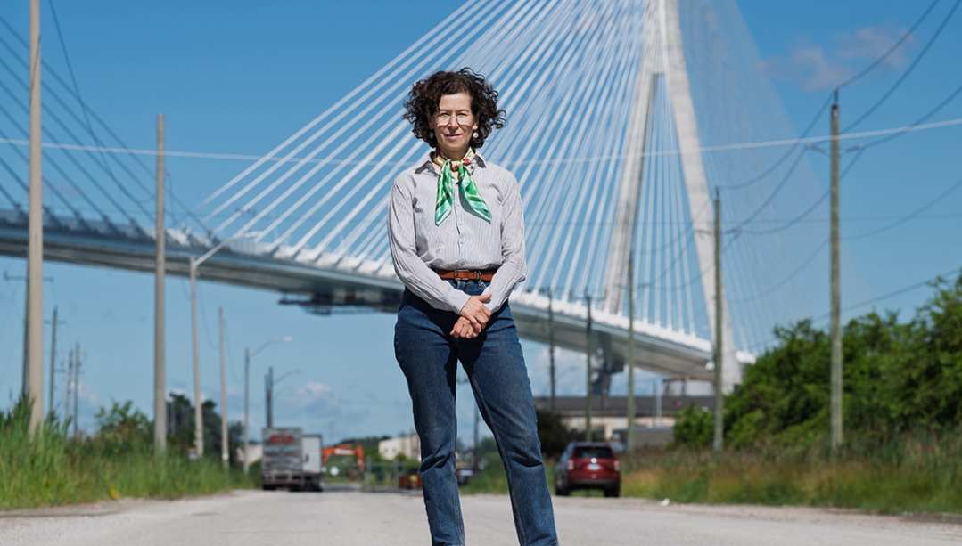 photo of Dr. Lee Rodney standing in front of the new Gordie Howe Bridge