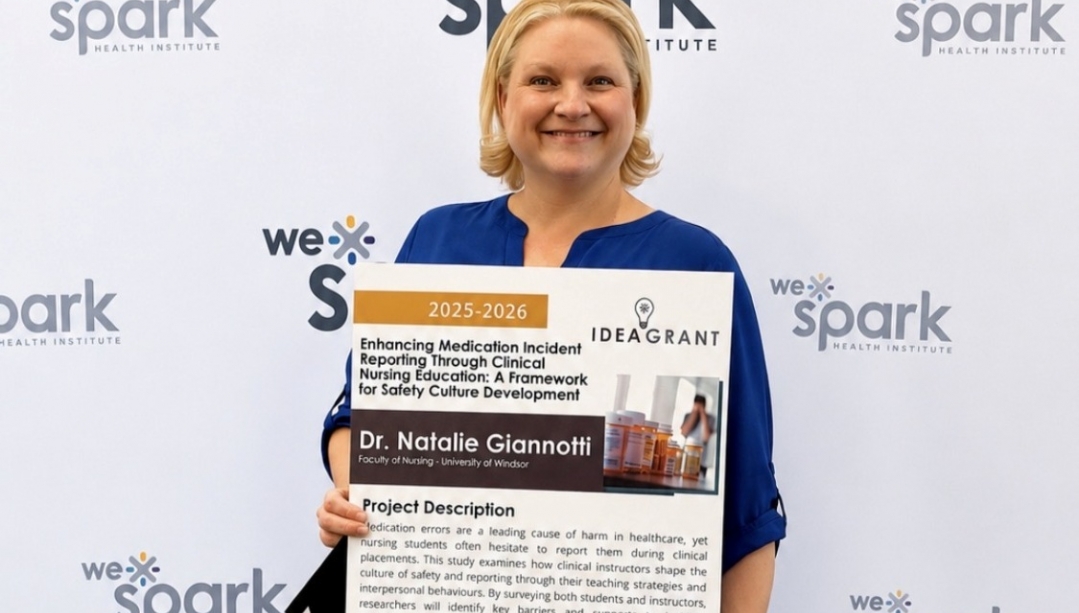 Natalie Giannotti holds a poster for her WeSpark grant project