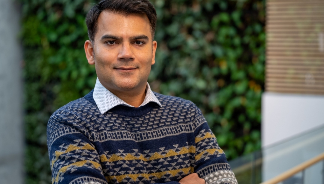 Dr. Noeman Mirza stands in front of a living wall in the faculty of nursing