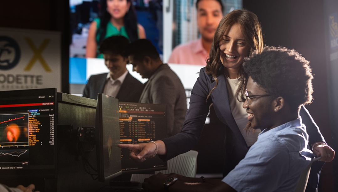 group of students sitting around computer in classroom